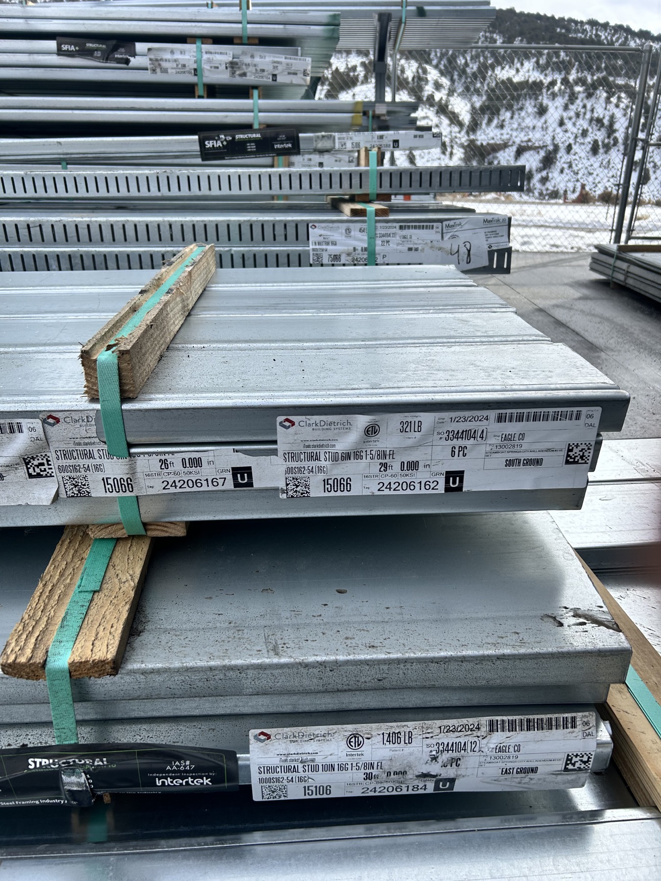 Bundles of steel studs stacked in an Outwest yard
